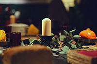 table setting with a candle in the center and surrounded by leaves.